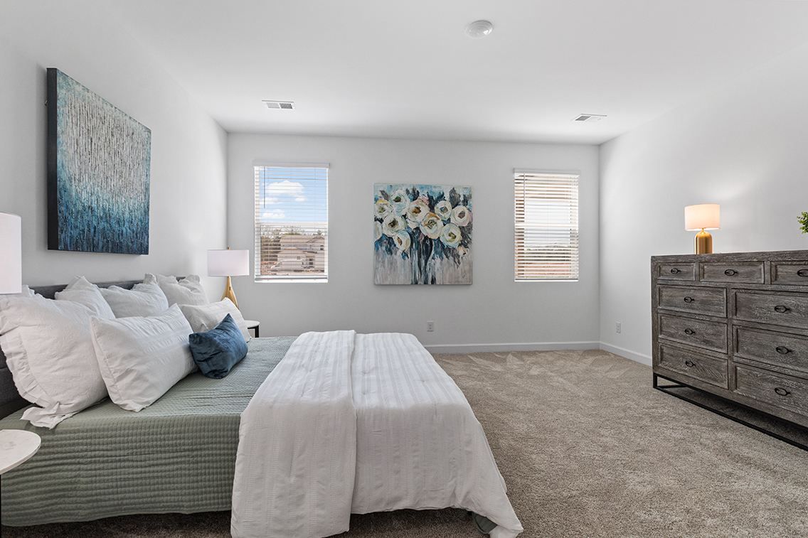 A bedroom with a bed and a painting on the wall.