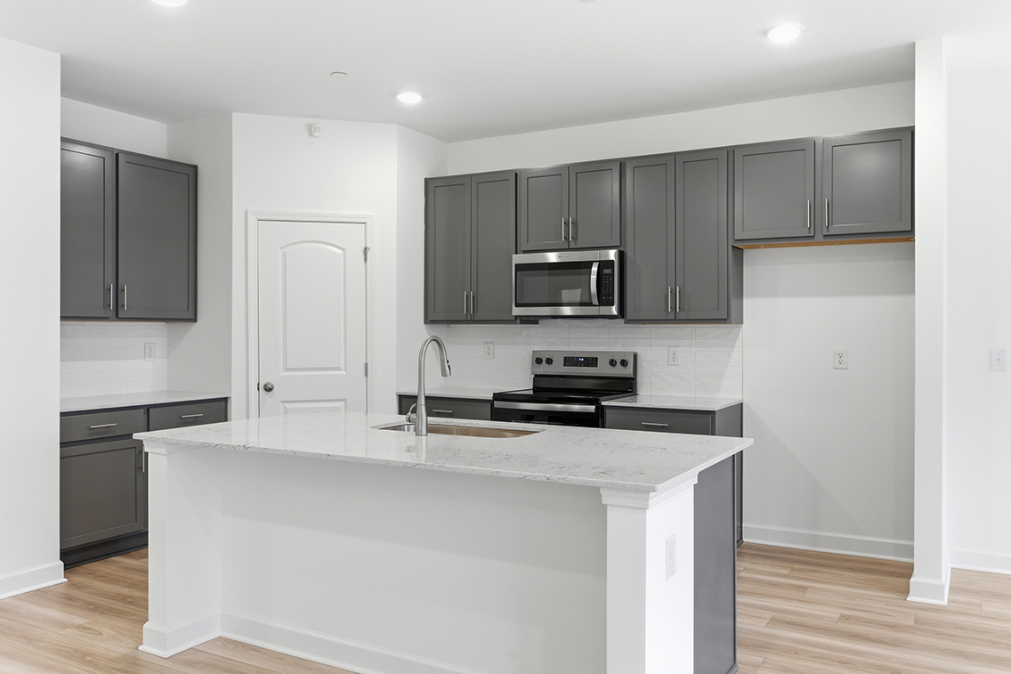 A kitchen with black cabinets.