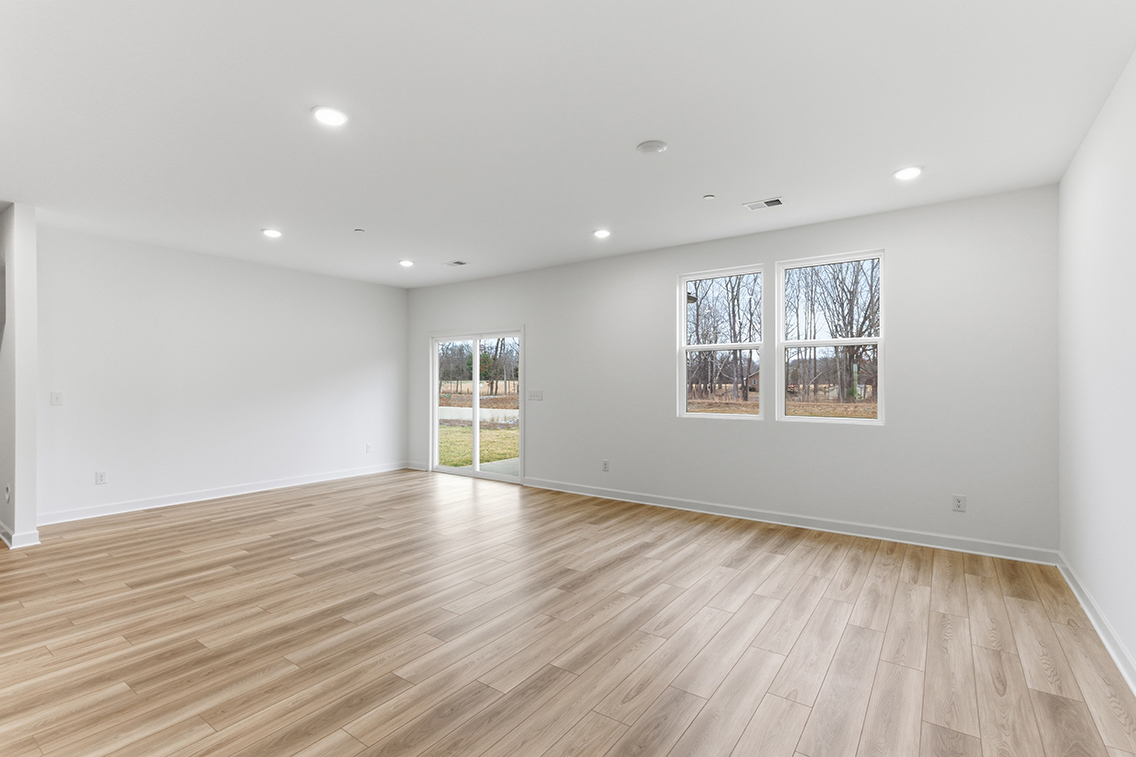 A room with a wood floor and windows.