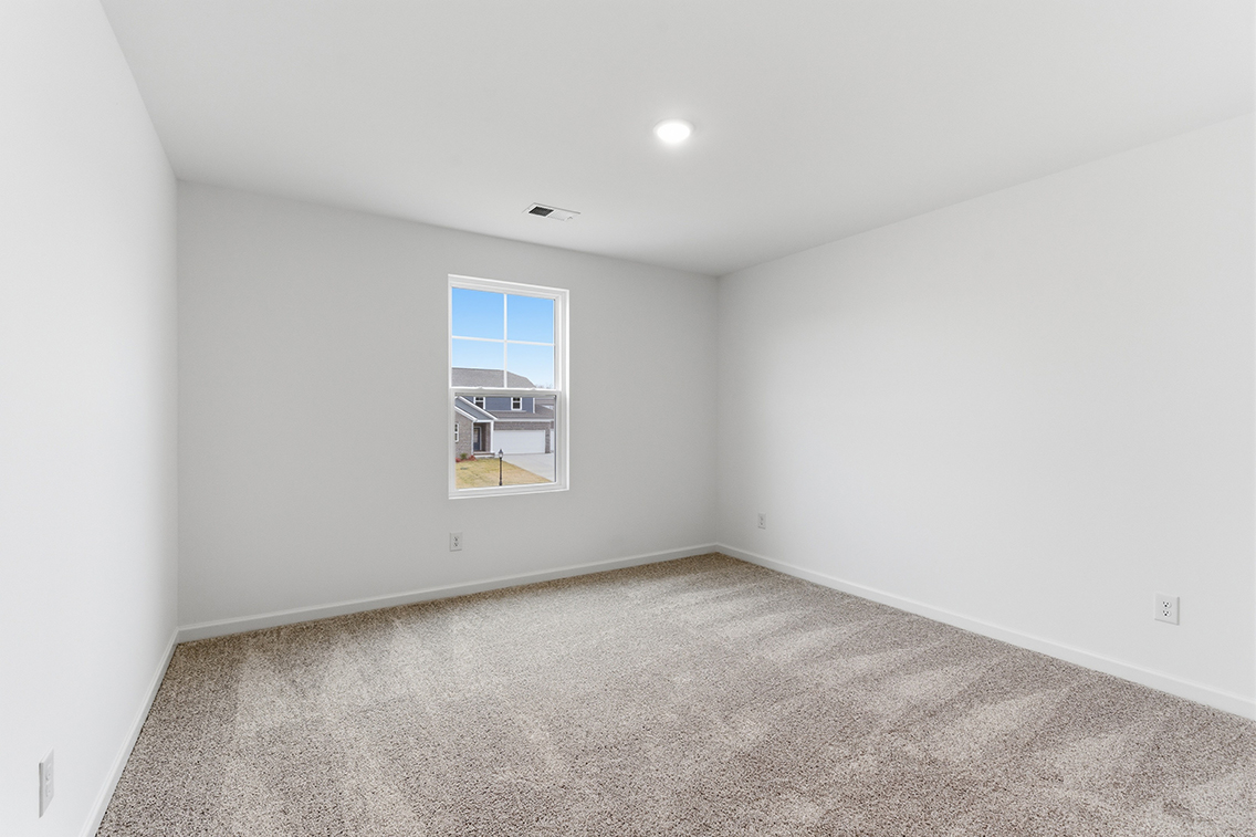 A room with a window and carpet.