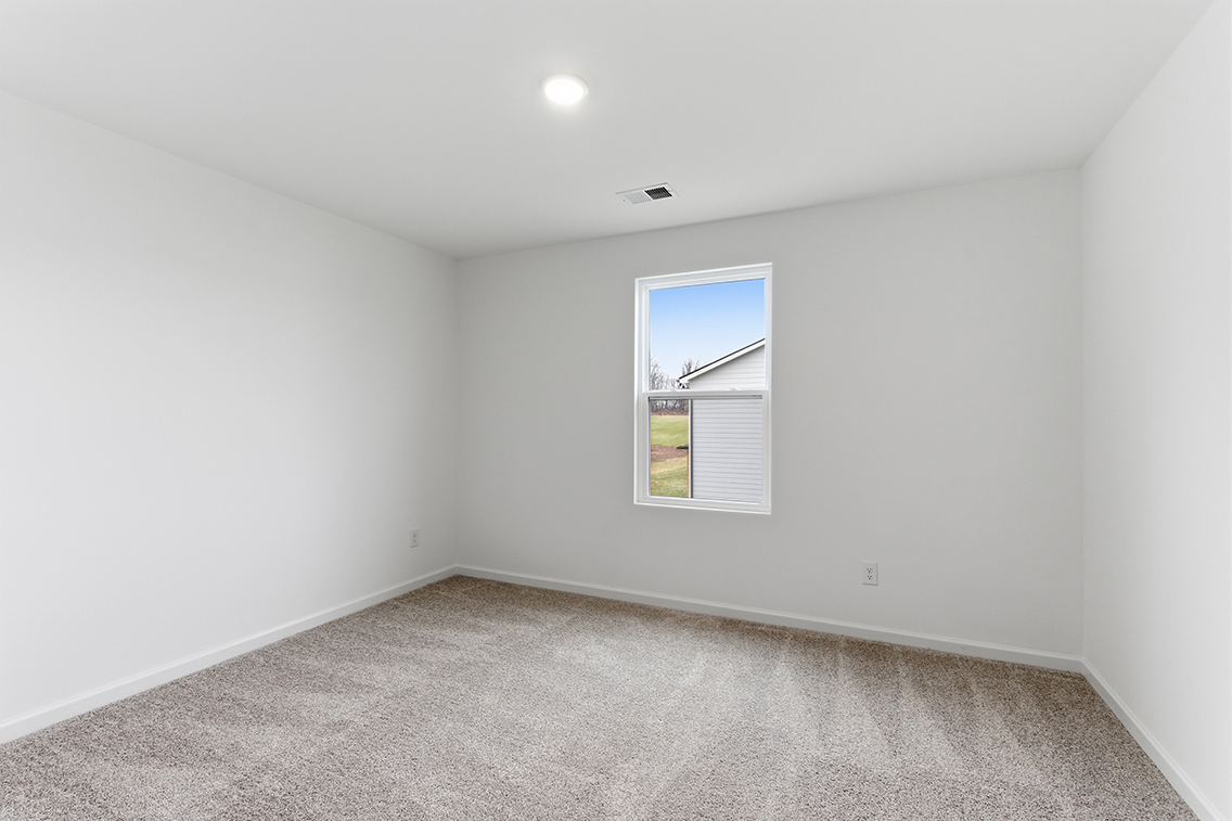 A room with a window and a carpet.