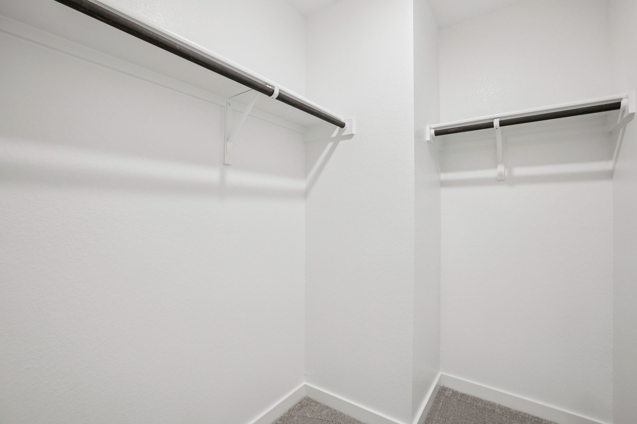 A white wall with a metal bar.