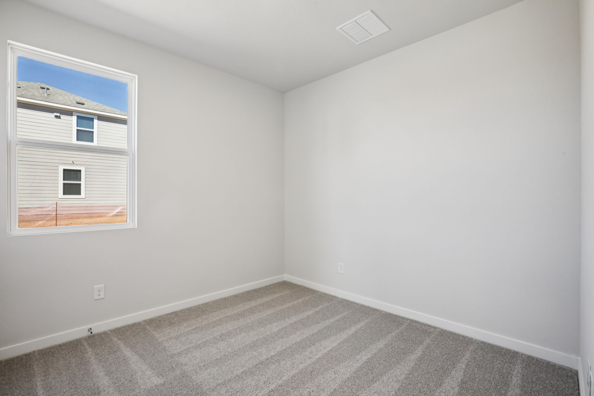 A room with a window and a rug.
