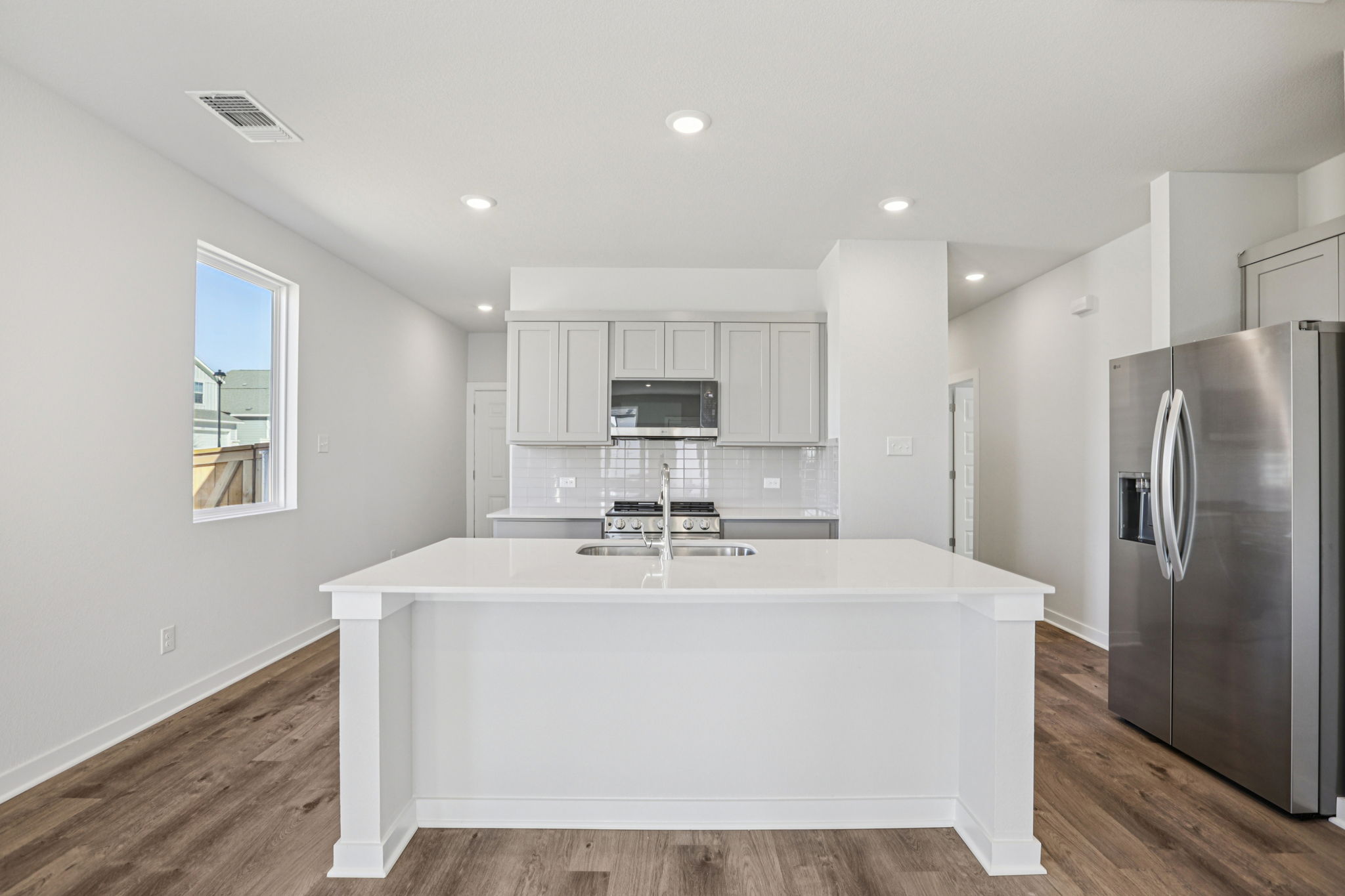 A kitchen with white cabinets.
