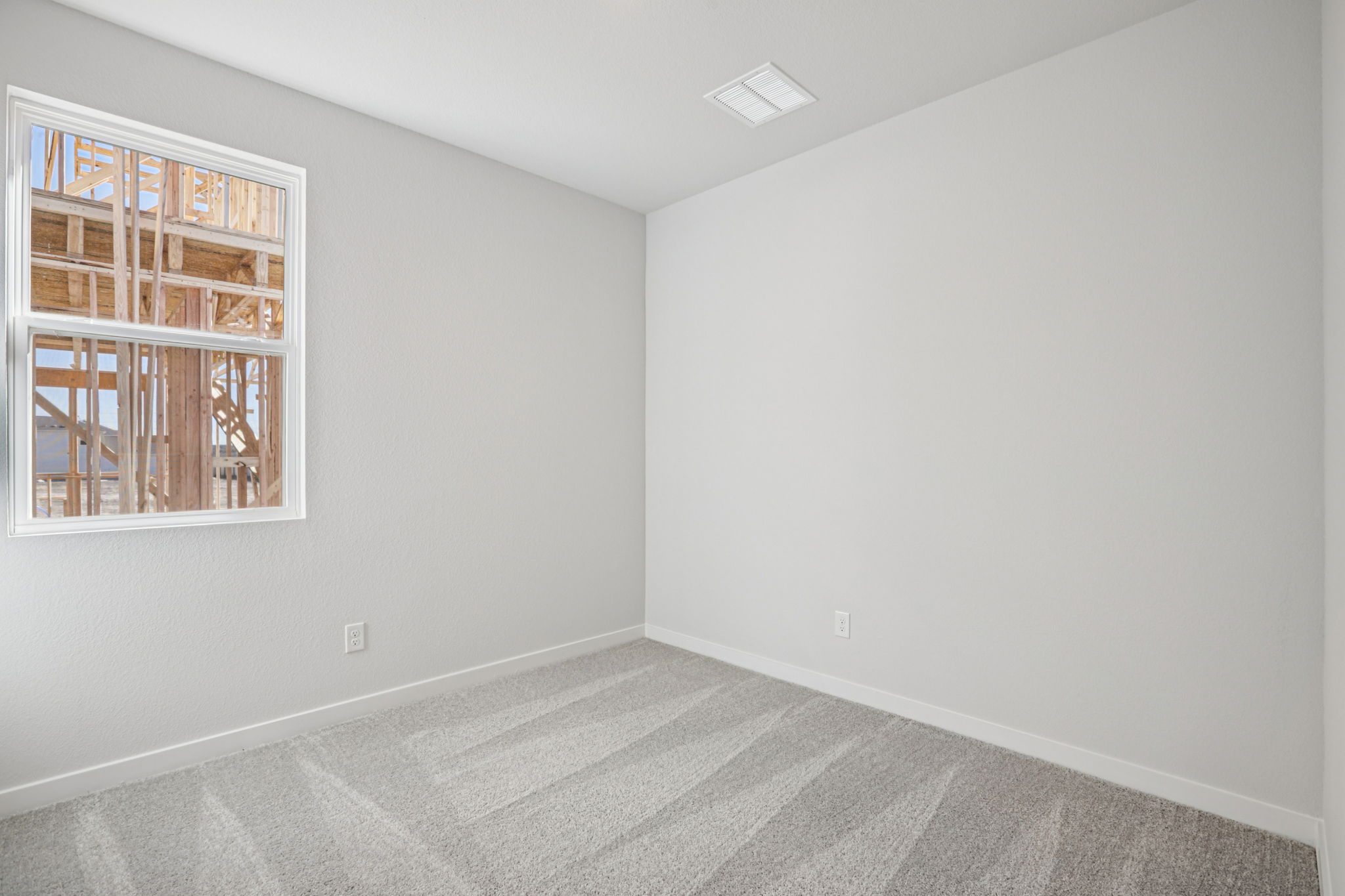 A room with a window and a rug.