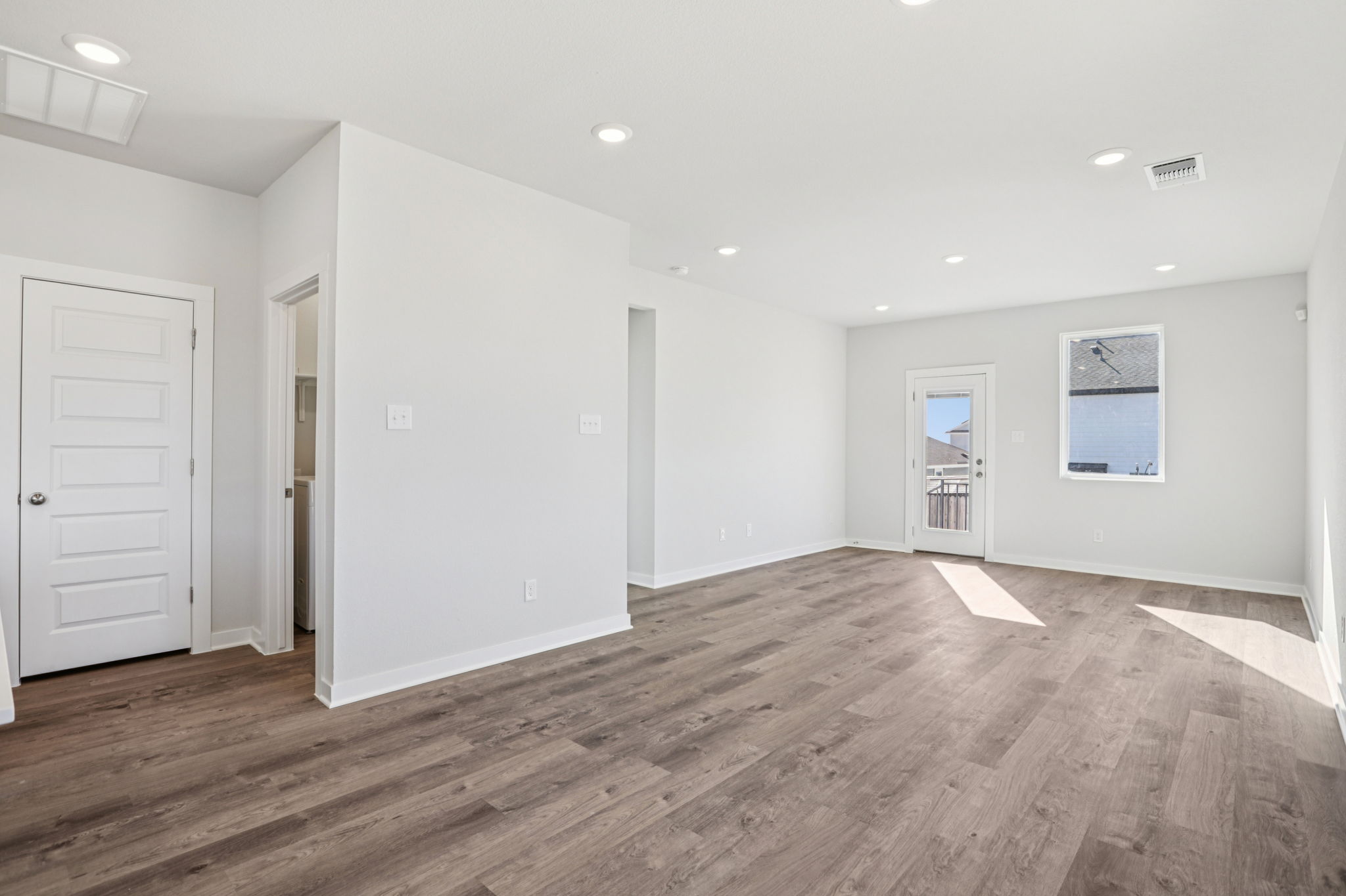 A room with white walls and wood floors.