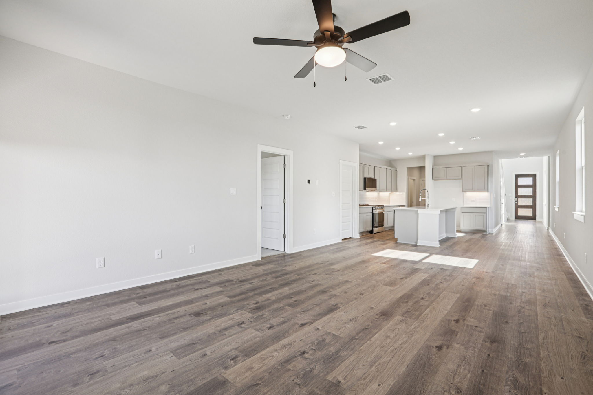 A room with a wood floor and a ceiling fan.