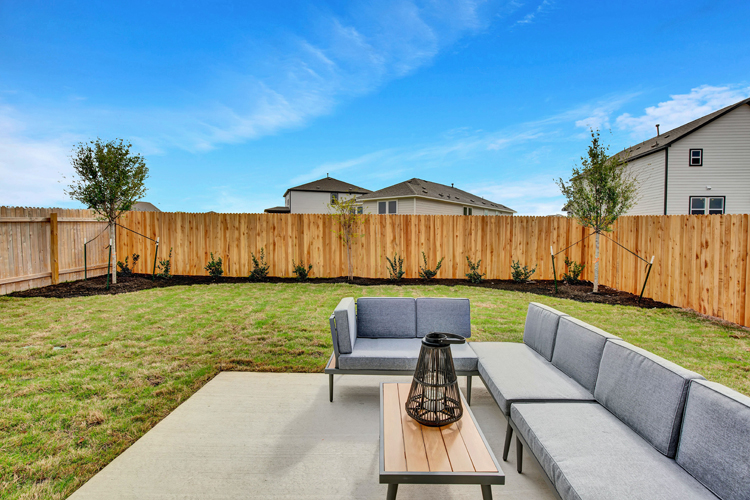 A backyard with a patio and a table and chairs.
