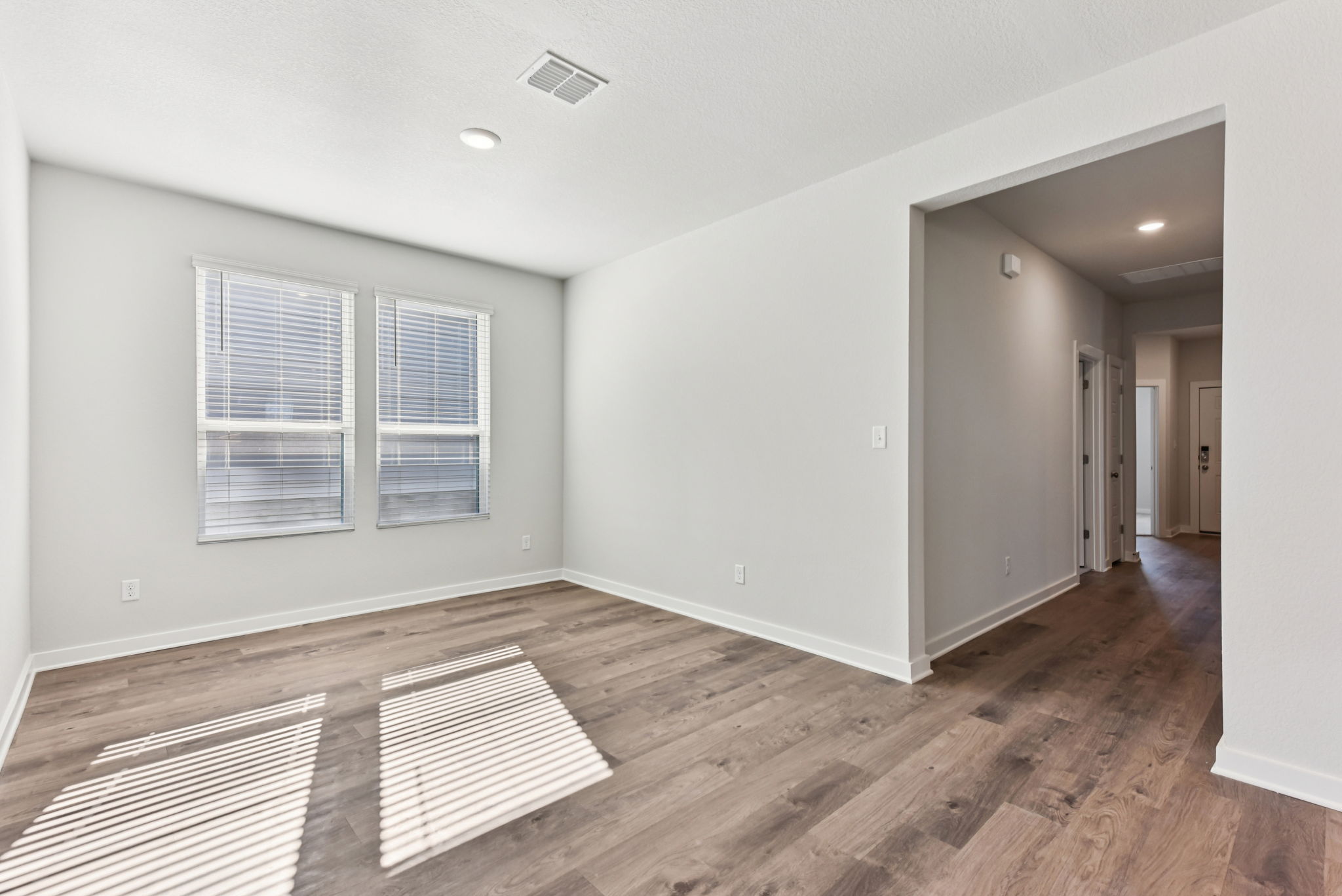 A room with a wood floor and a rug.
