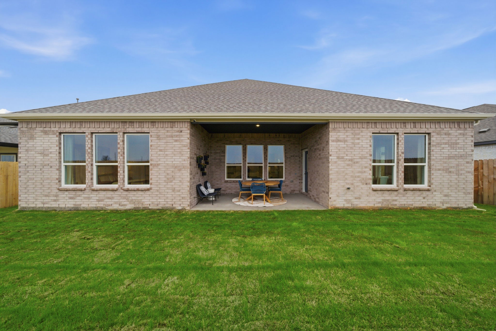 A house with a lawn and chairs.