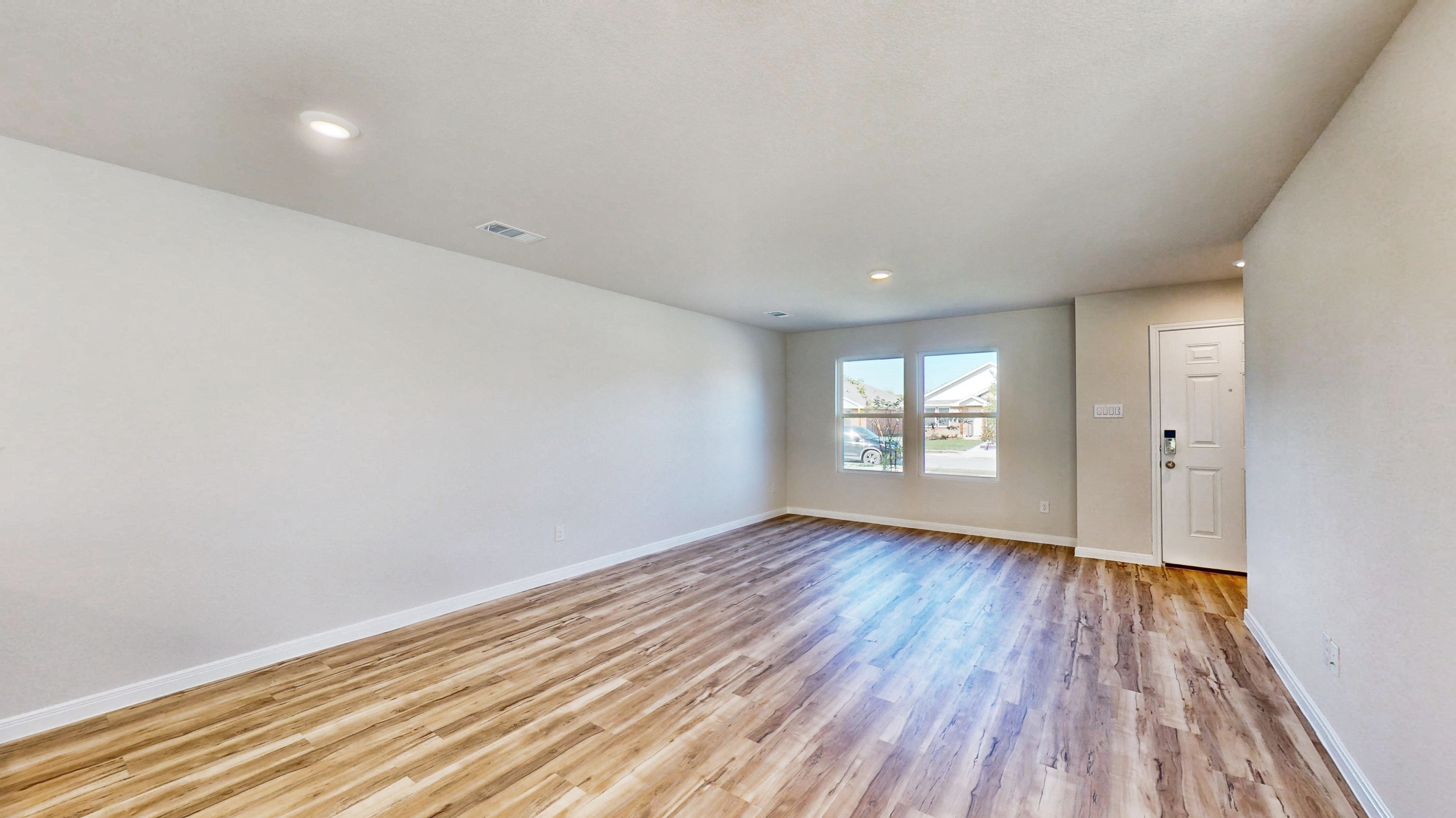 A room with a wood floor and a wood floor with a window.