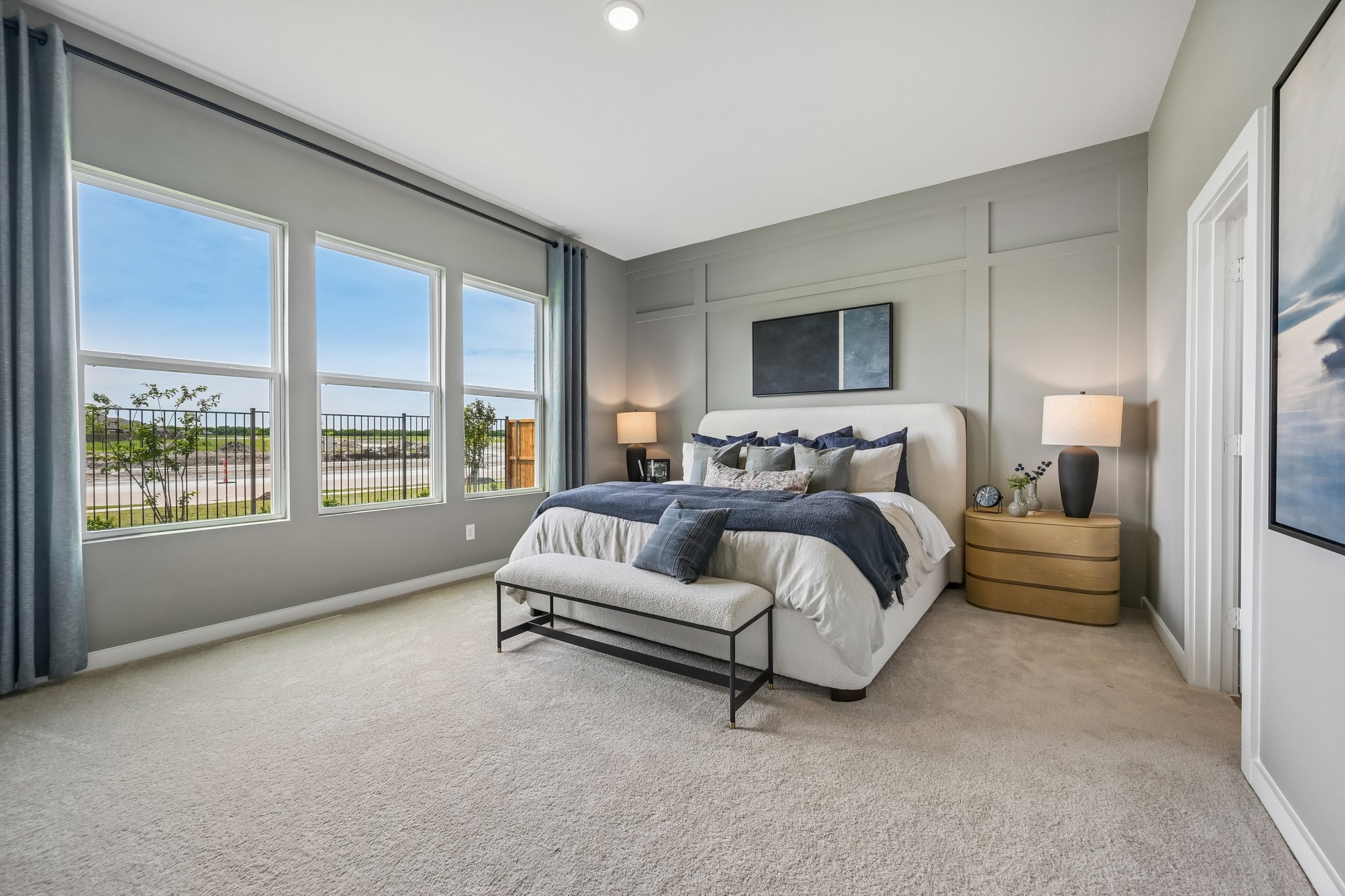 A bedroom with a bed and a bench.