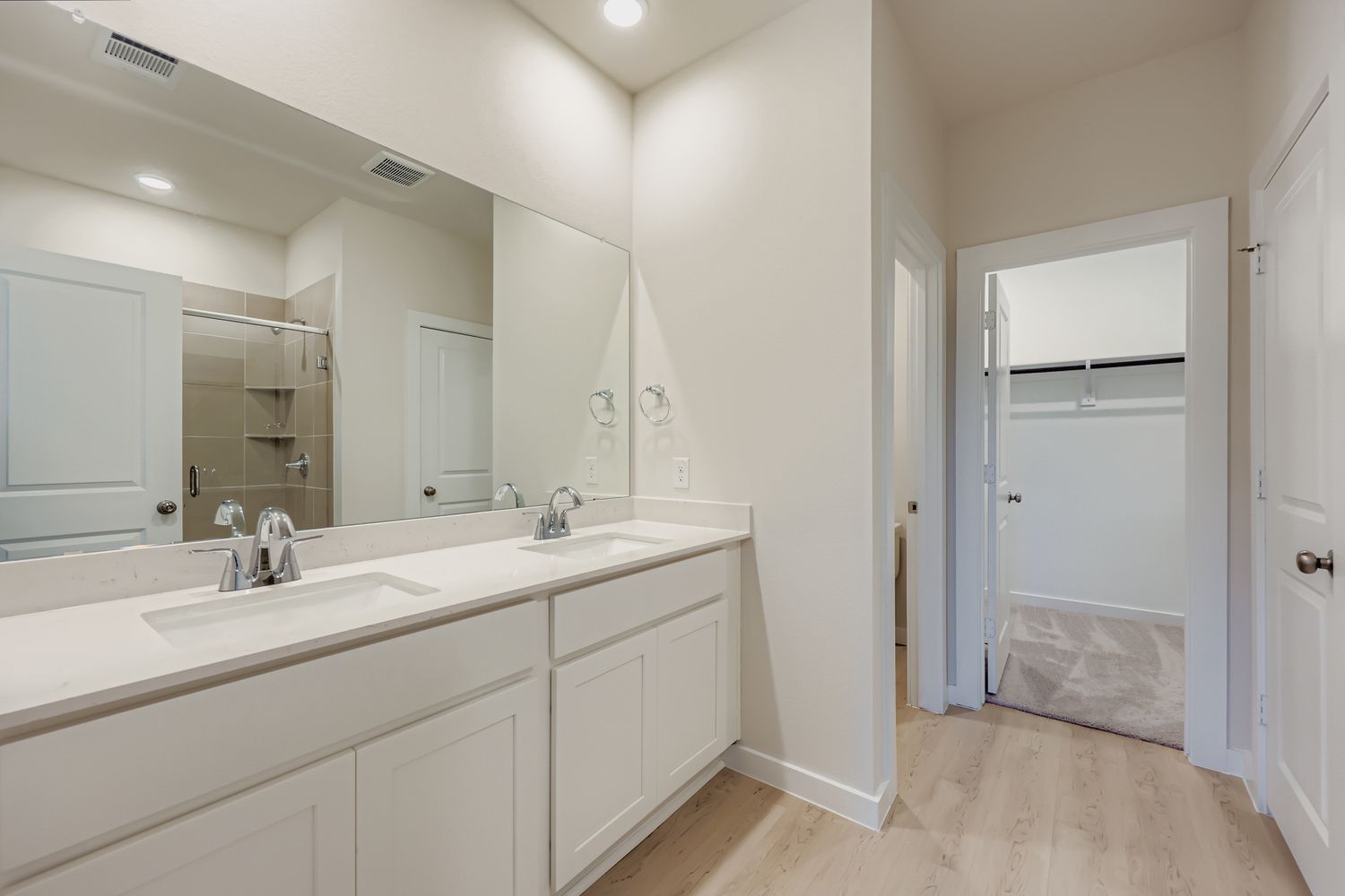 A bathroom with white cabinets.
