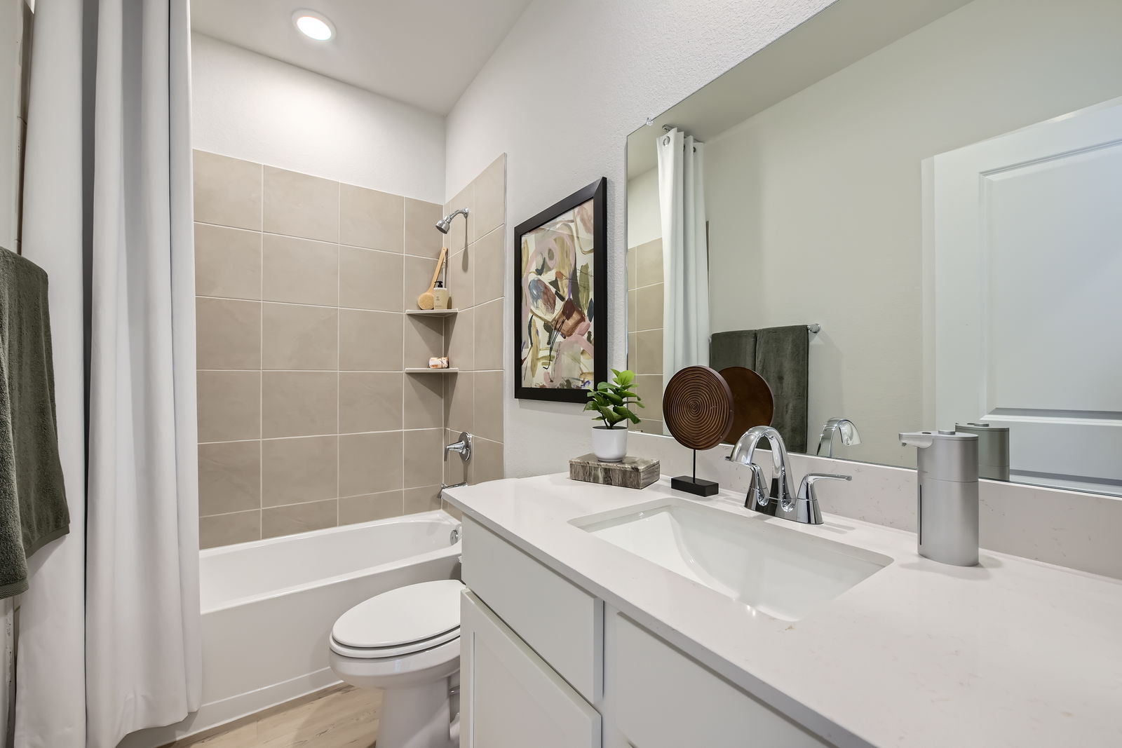 A bathroom with a sink toilet and a mirror.