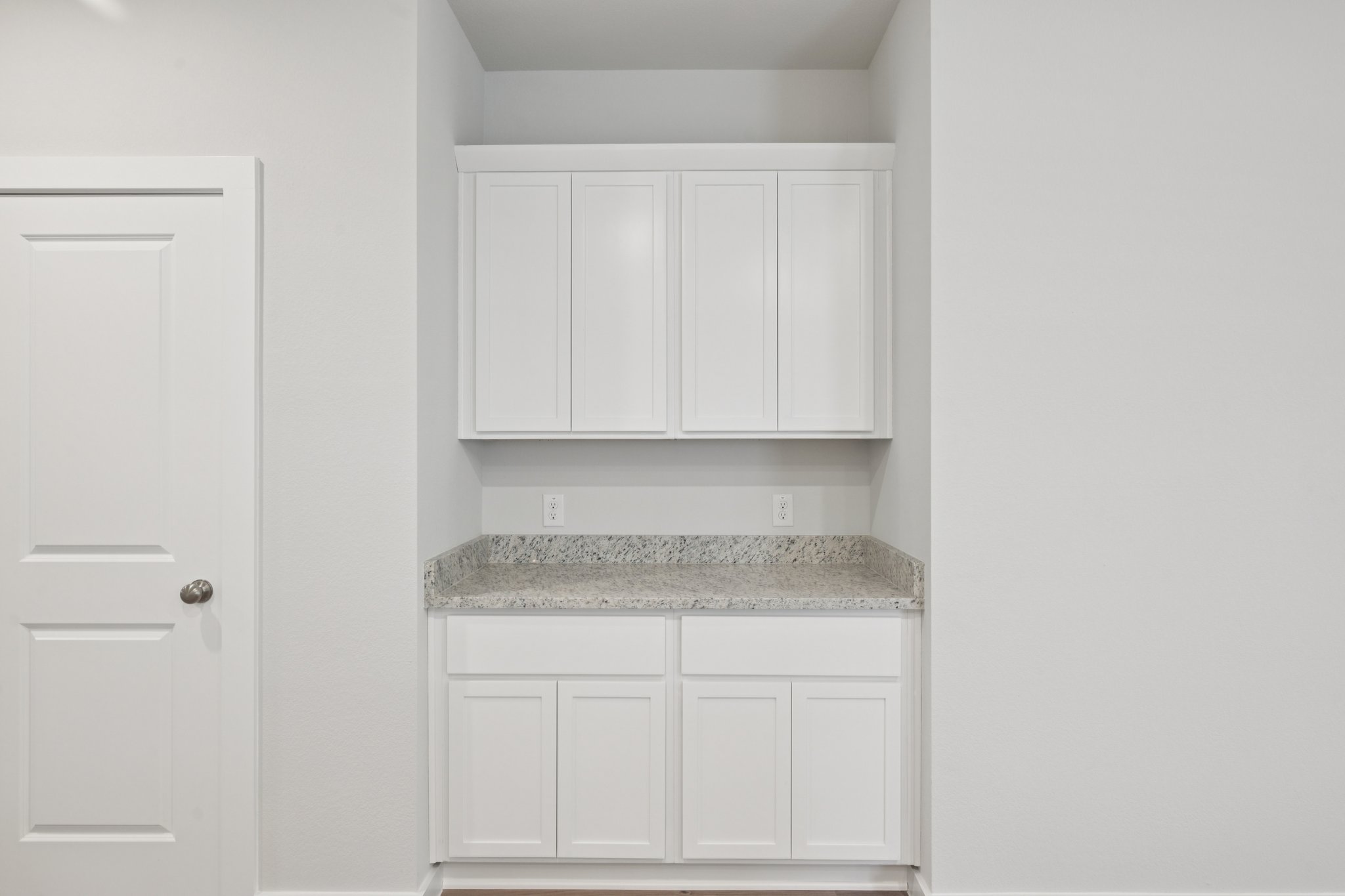 A kitchen with white cabinets.