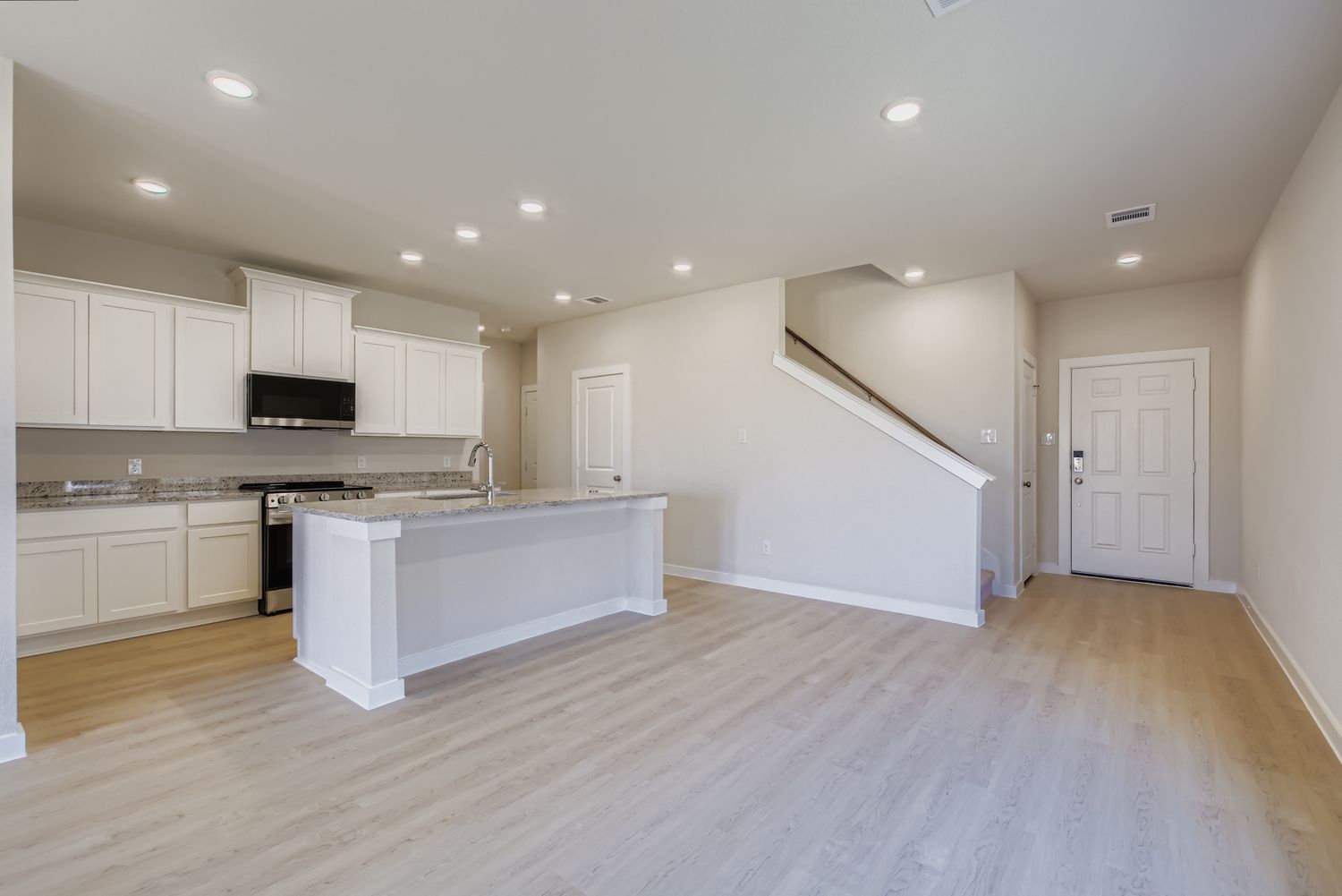 A kitchen with white cabinets.