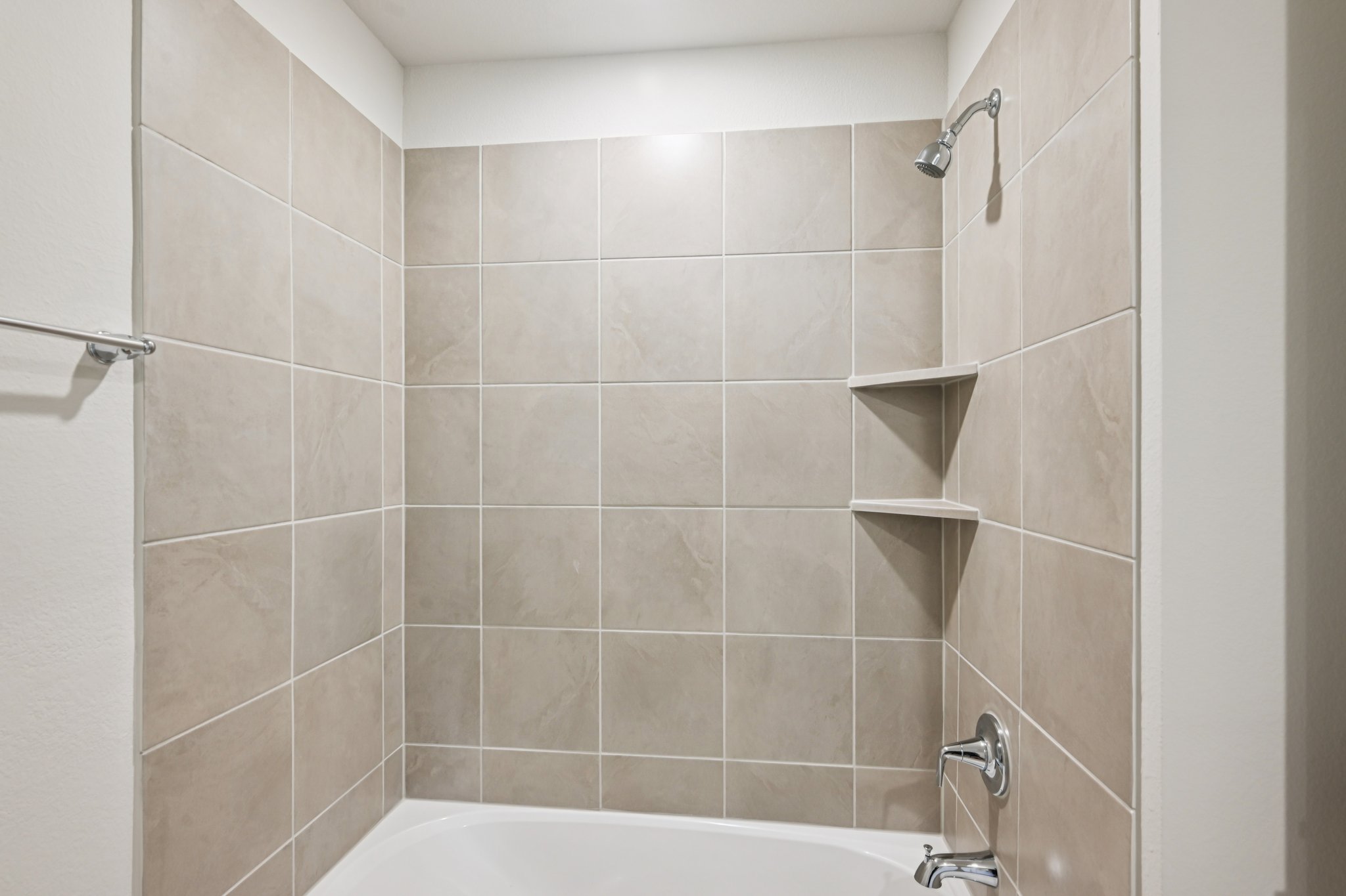 A bathroom with a bathtub and shelves.