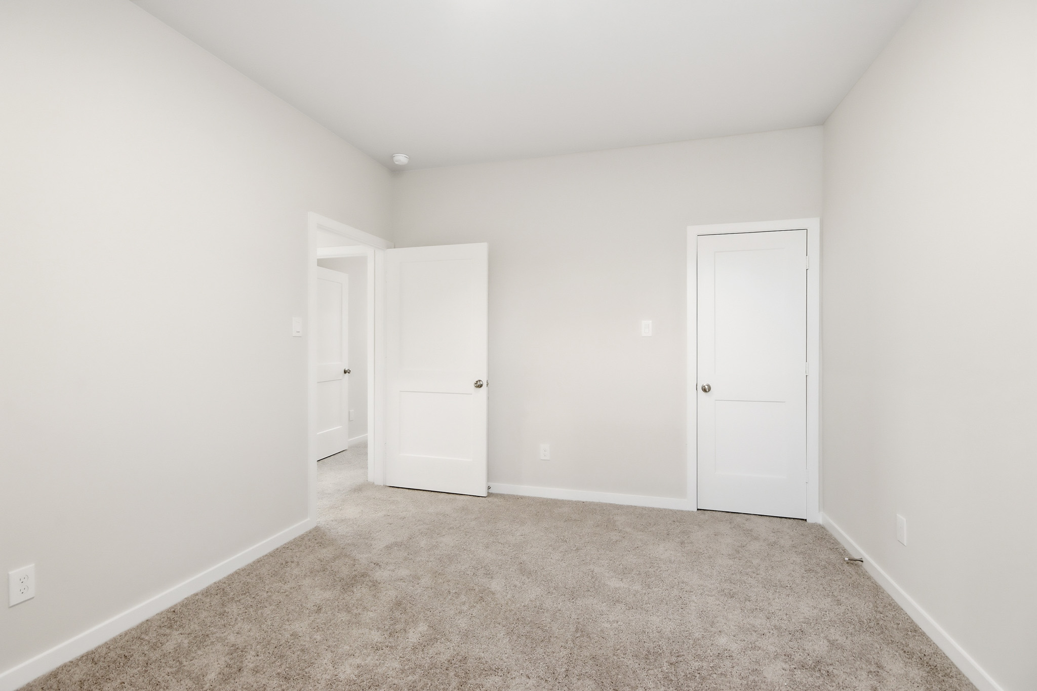 A hallway with white doors.