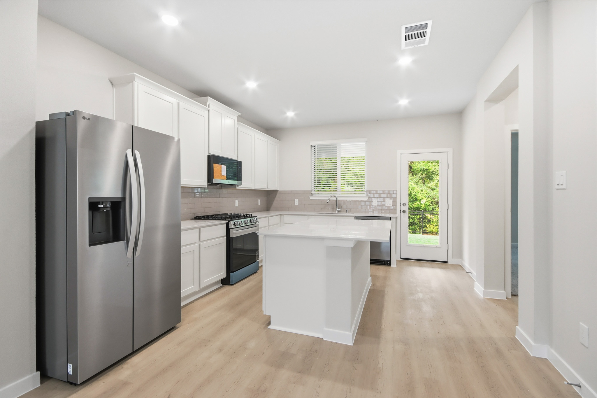 A kitchen with white cabinets.