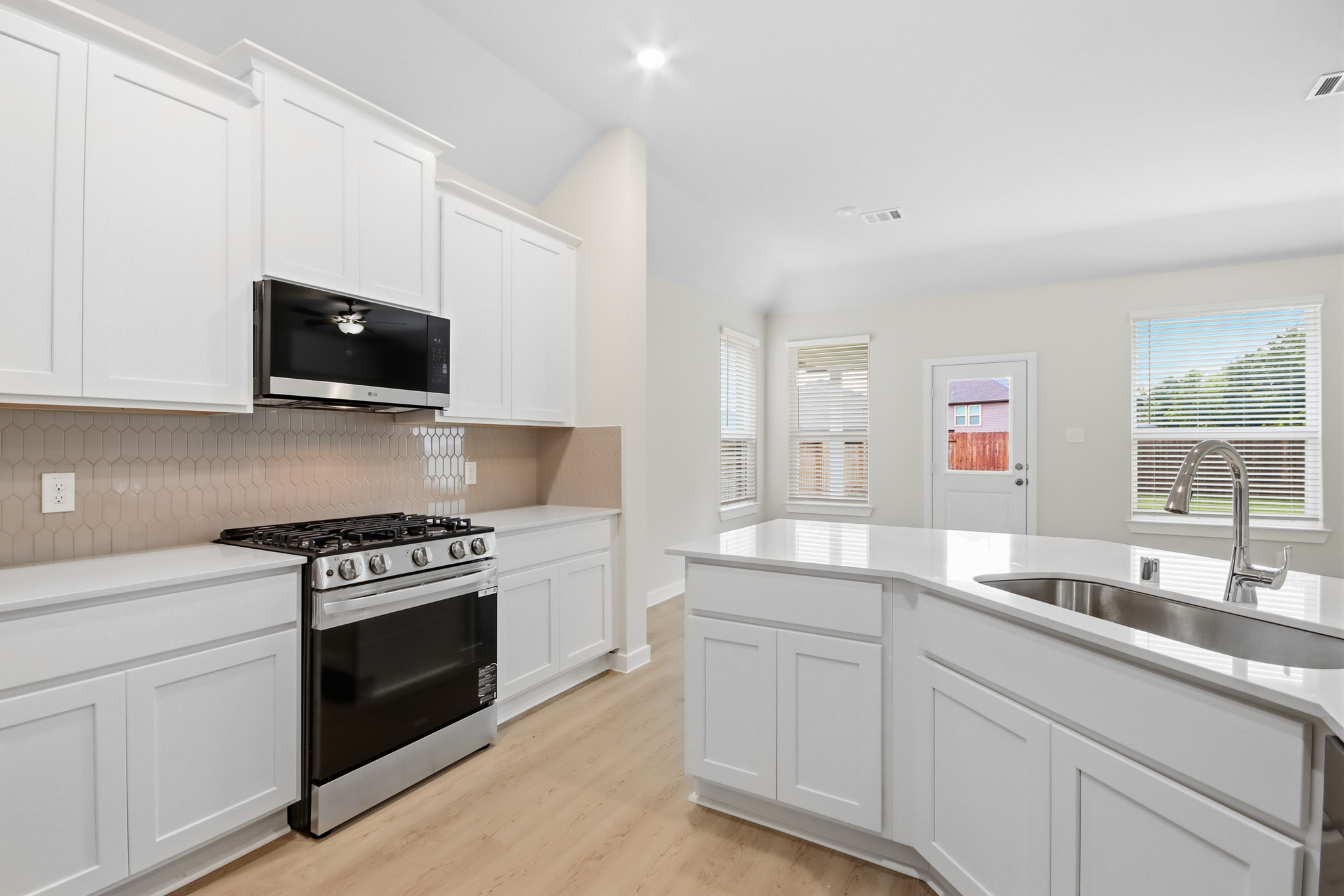 A kitchen with white cabinets.