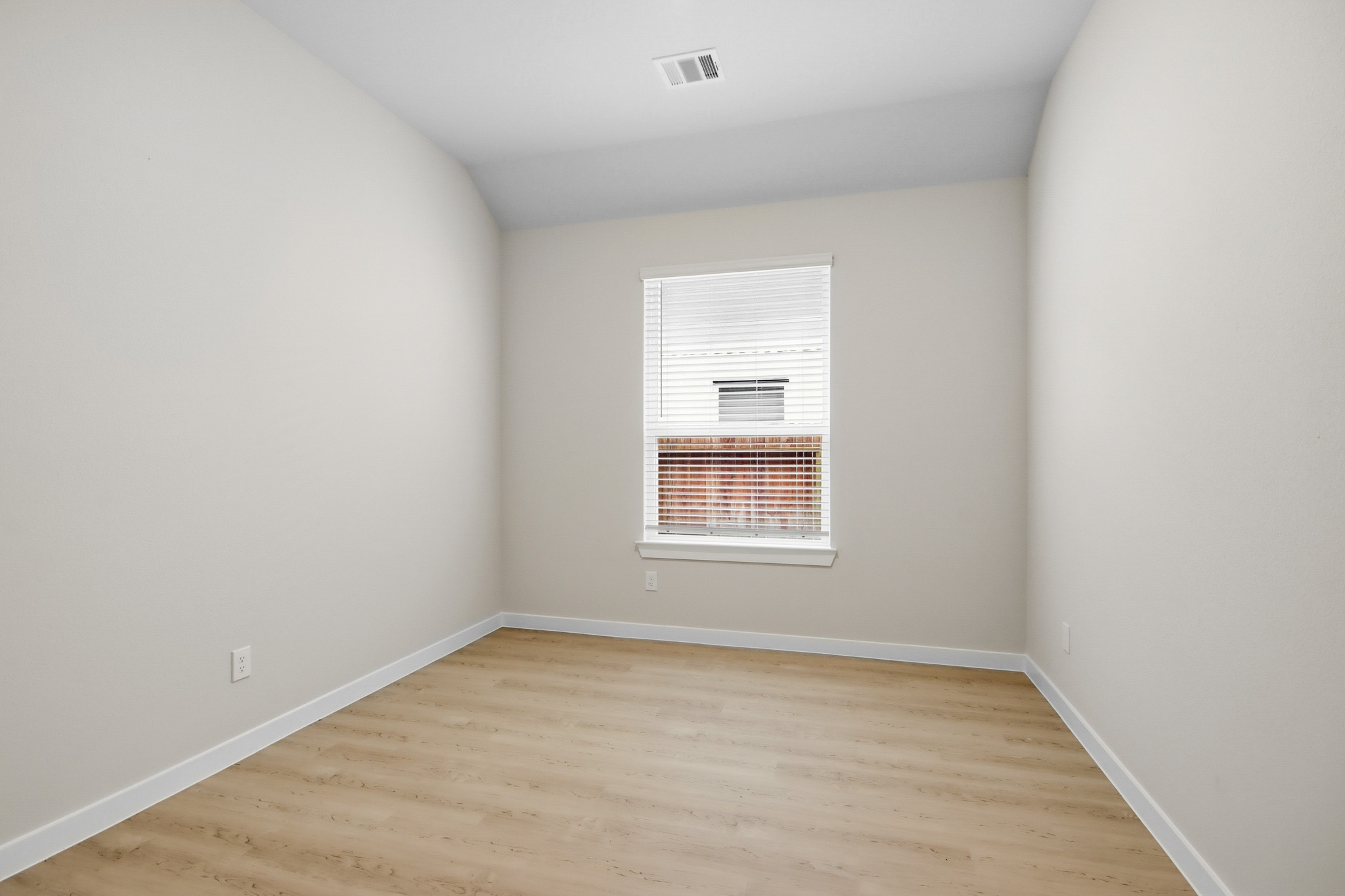 A room with a wood floor and a window.