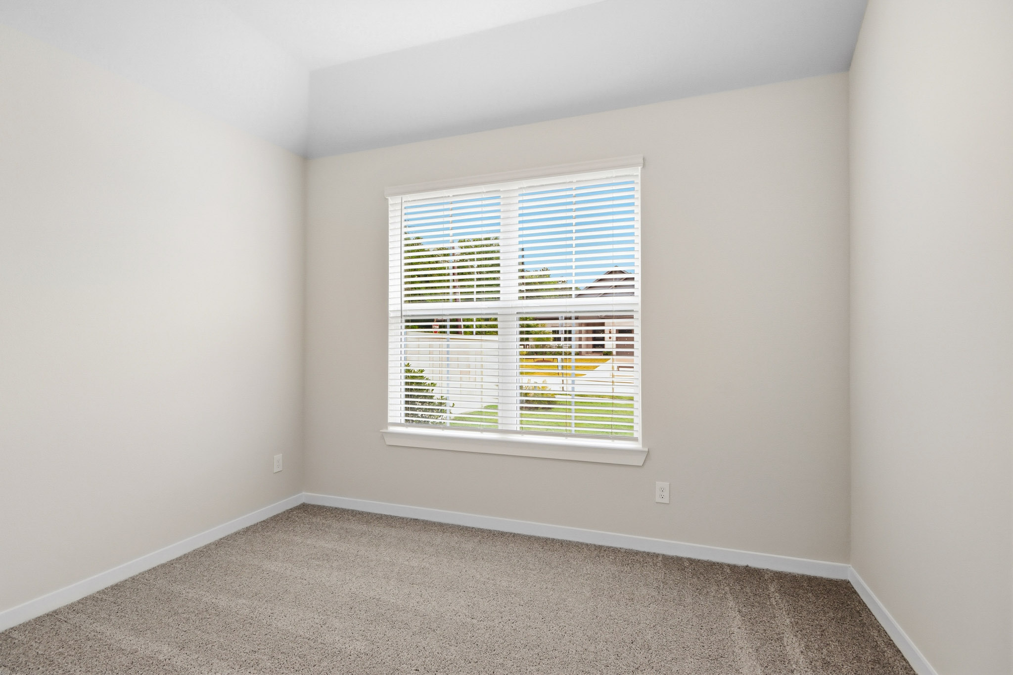 A room with a window and carpet.