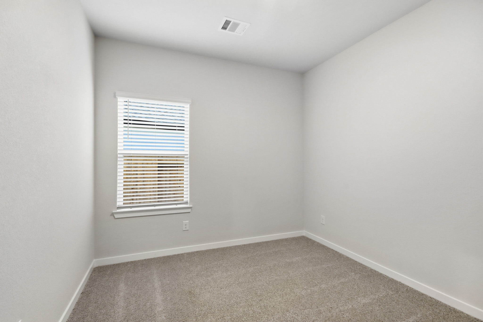 A room with a window and a carpet.