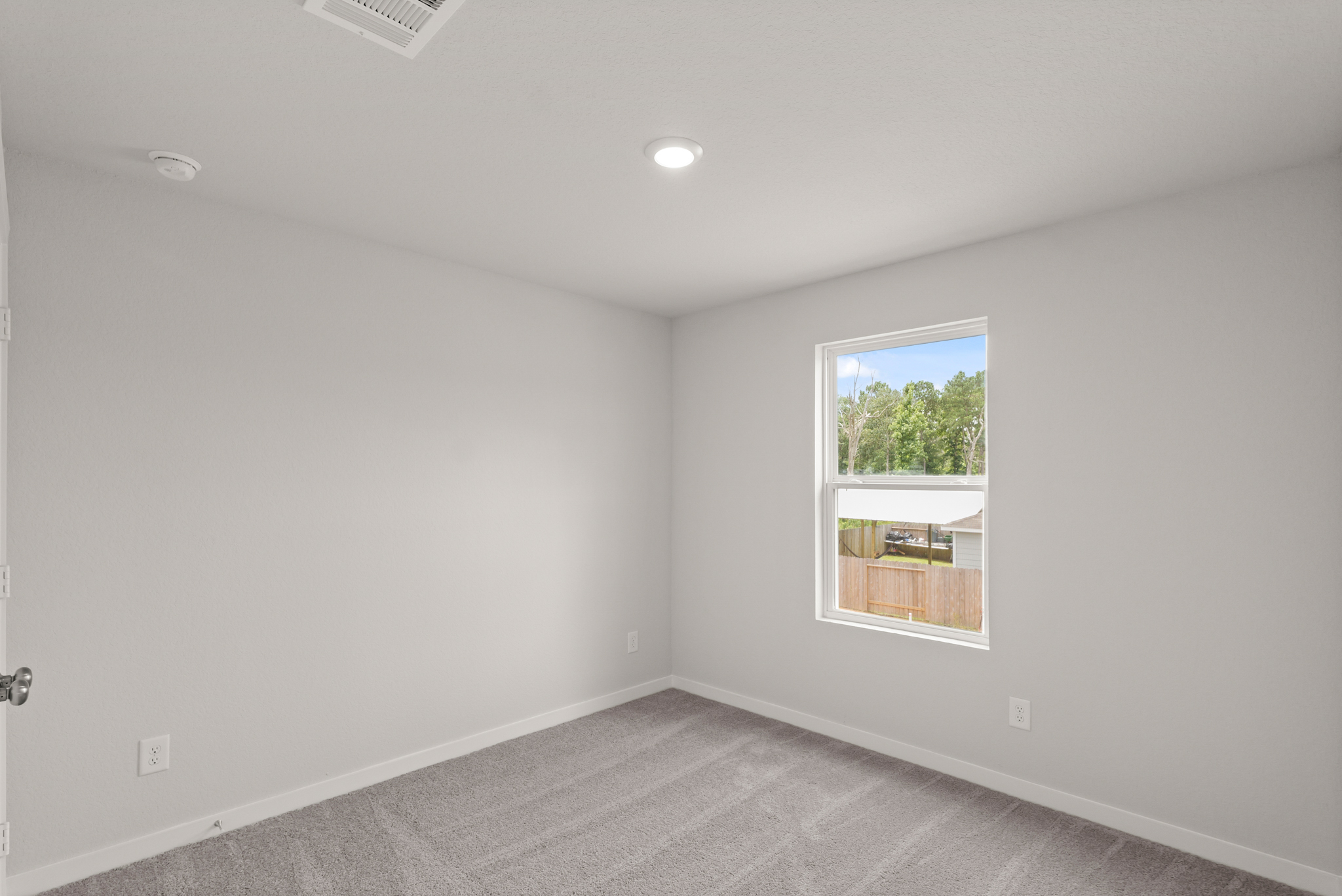 A room with a window and a carpet.