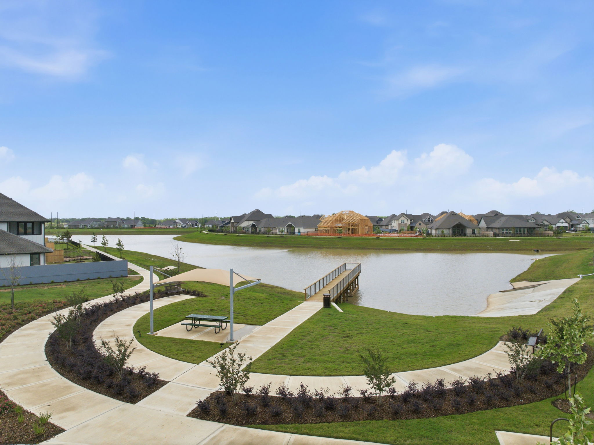 A pond with a bench and grass around it.
