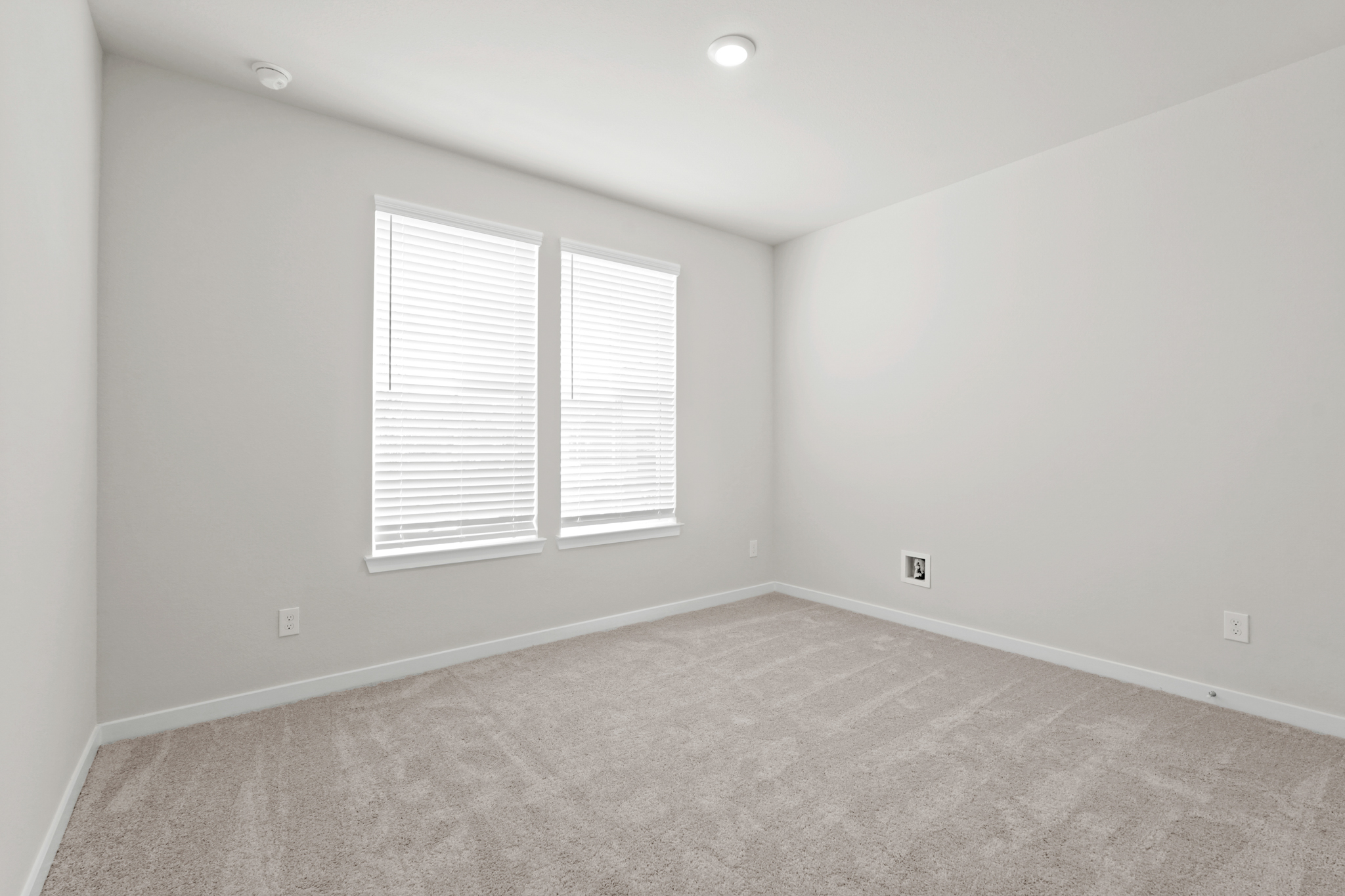 A room with a carpet and a window.