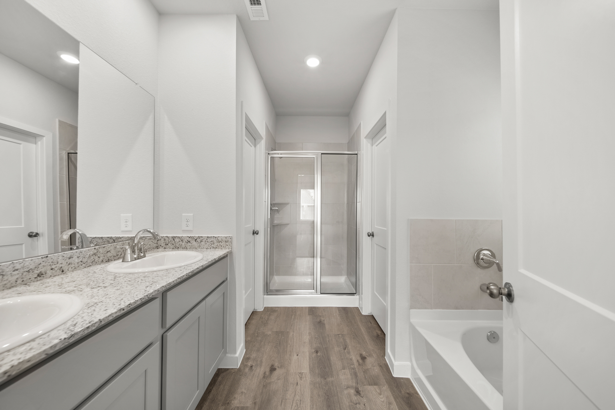 A bathroom with a tub sink and a mirror.