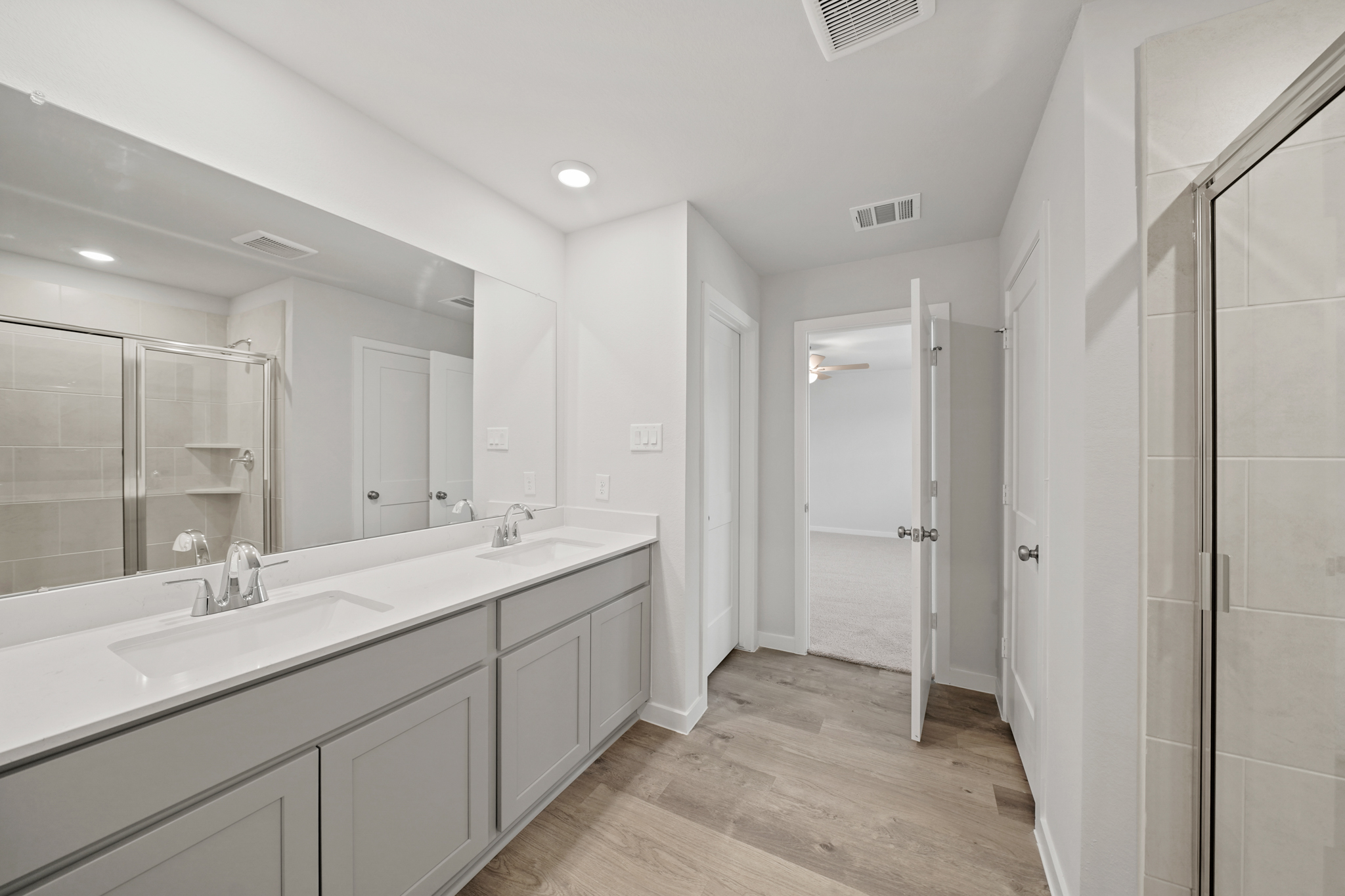A bathroom with white cabinets.