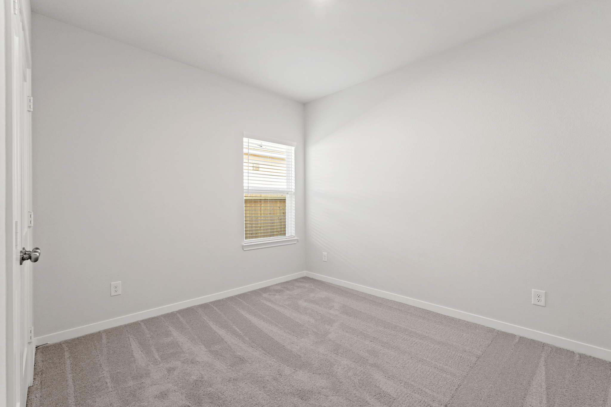 A room with a carpet and a window.