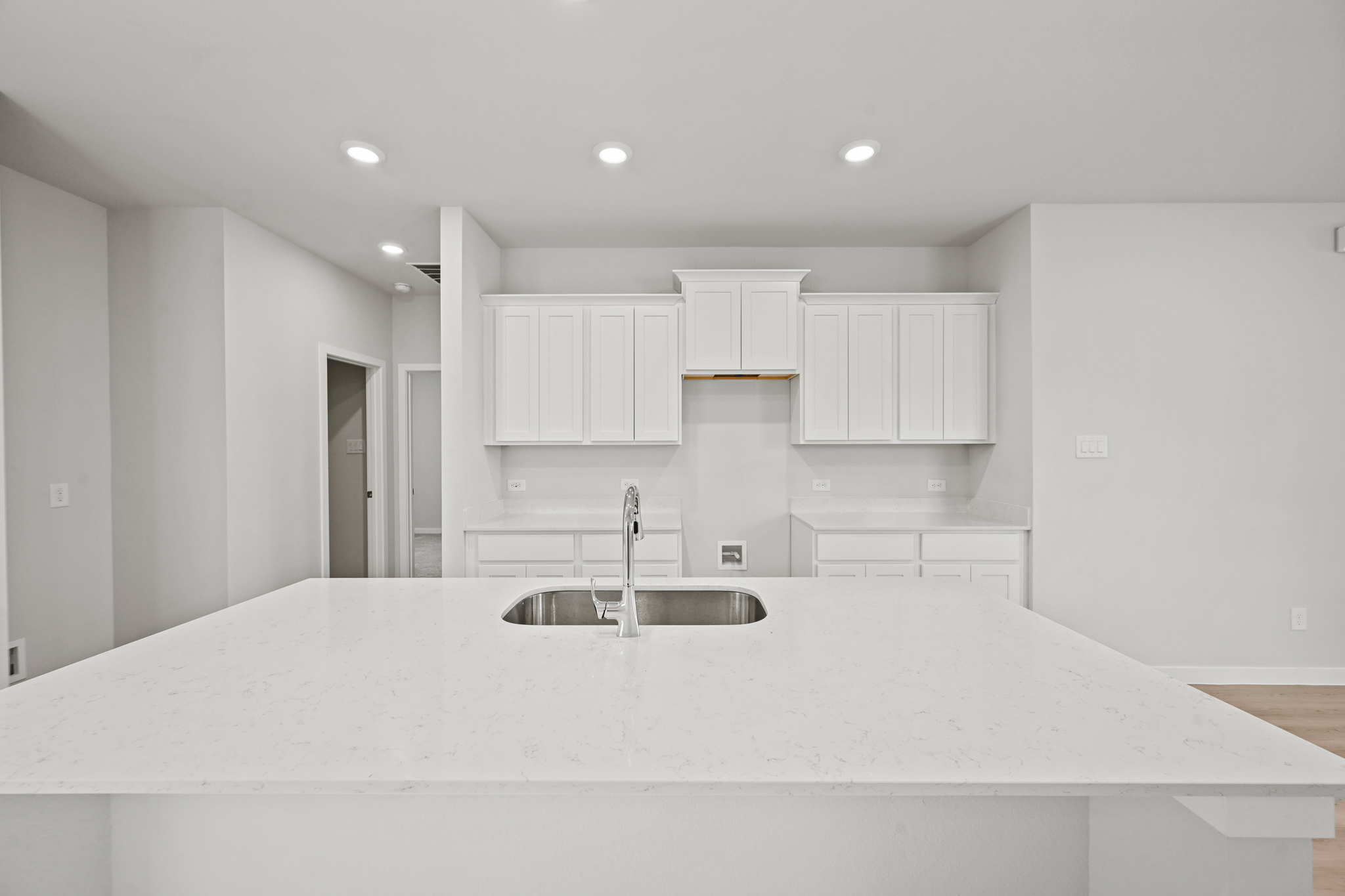 A kitchen with white cabinets.