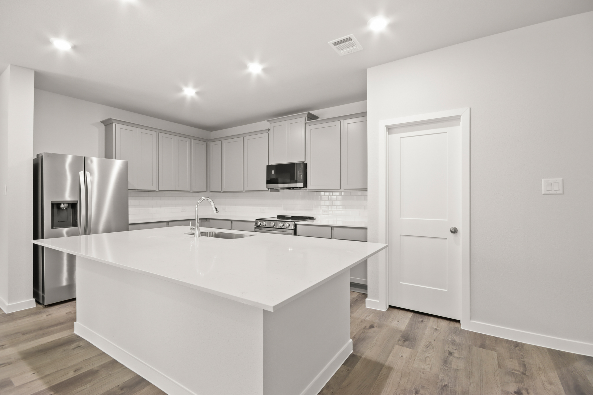 A kitchen with white cabinets.