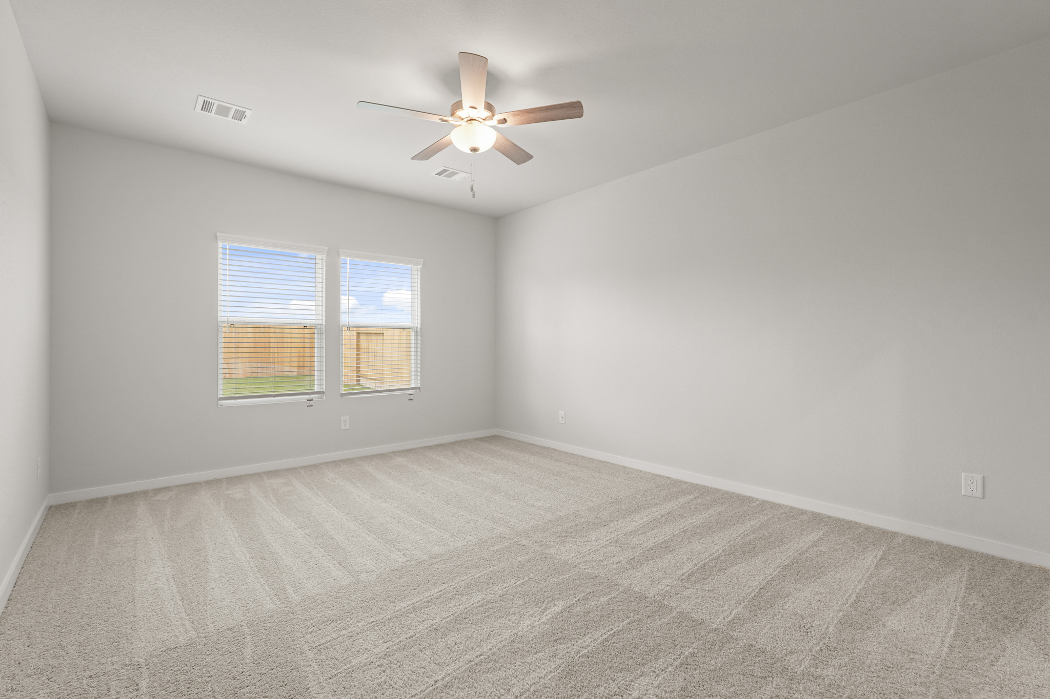 A room with a ceiling fan and a window.
