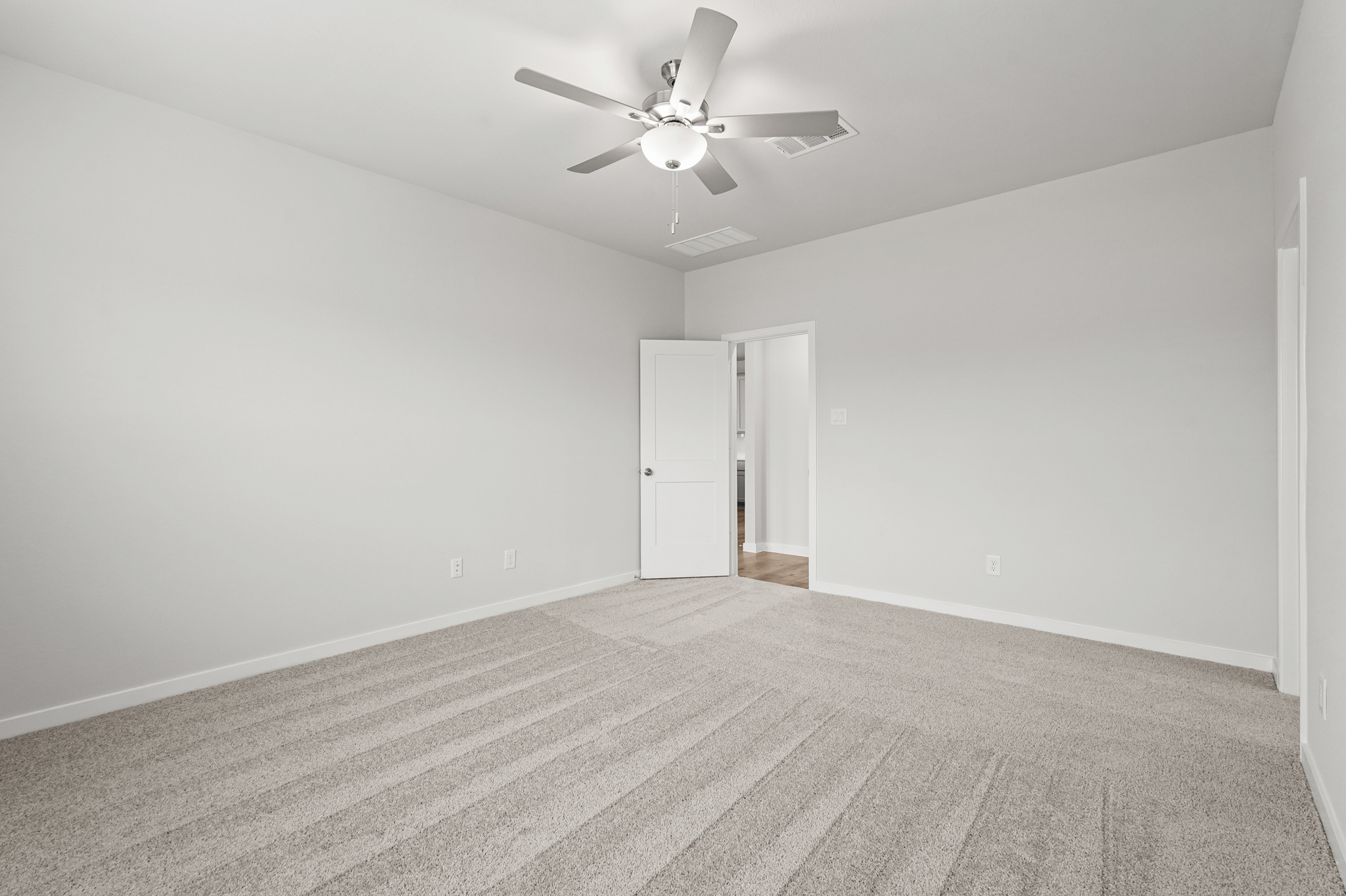 A room with a ceiling fan and a door.
