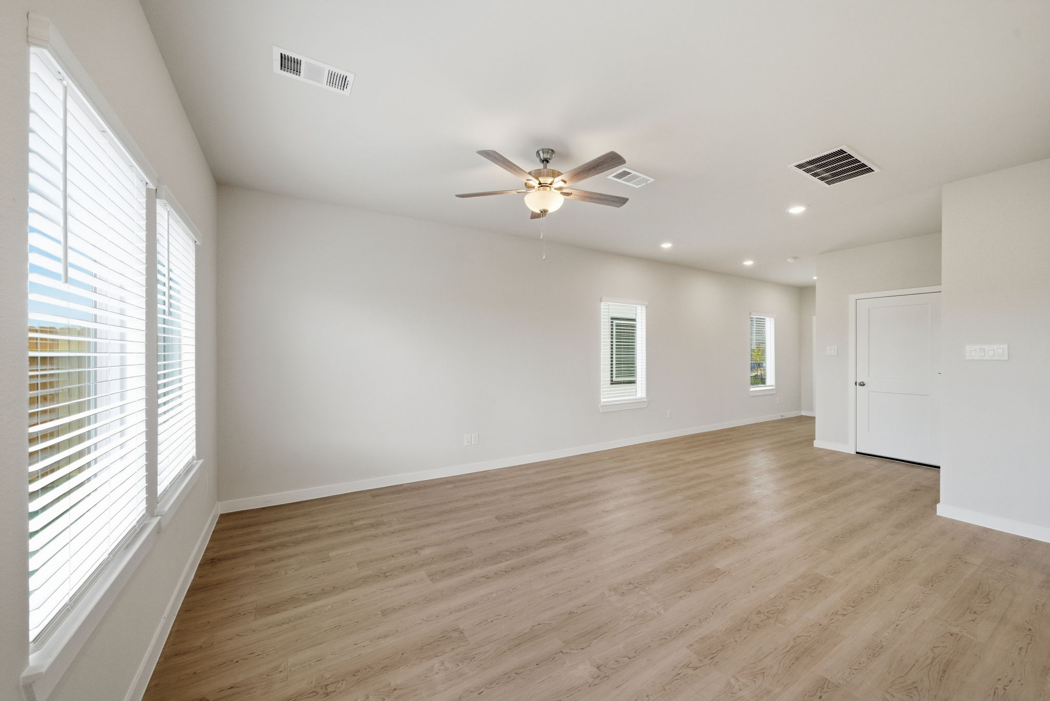 A room with a wood floor and a ceiling fan.