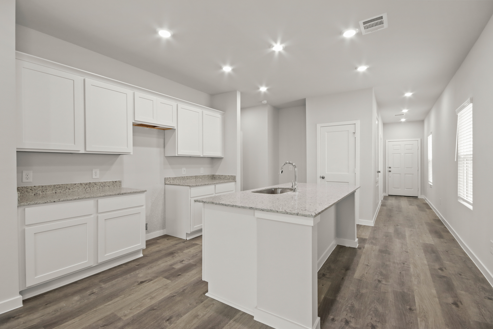 A kitchen with white cabinets.