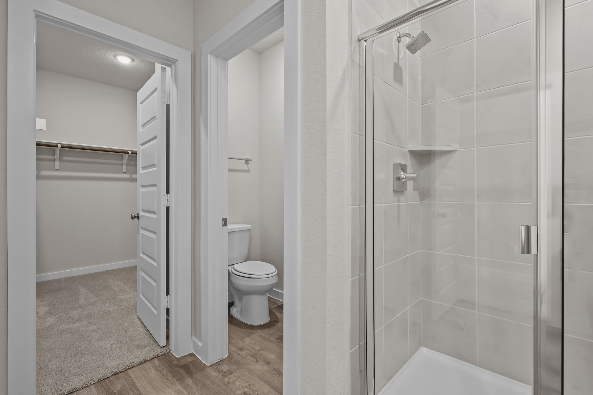 A bathroom with a shower unit and toilet.