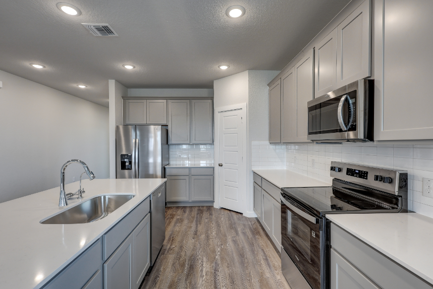 A kitchen with white cabinets.