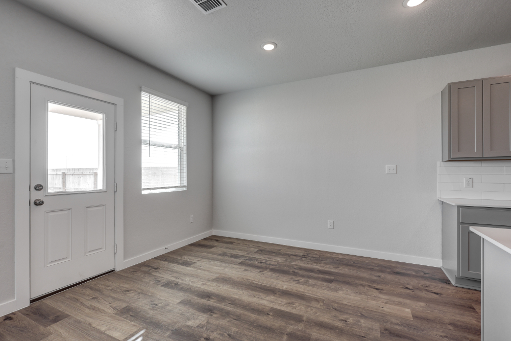 A room with white walls and wood floors.