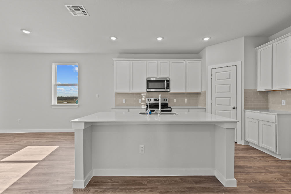 A kitchen with white cabinets.
