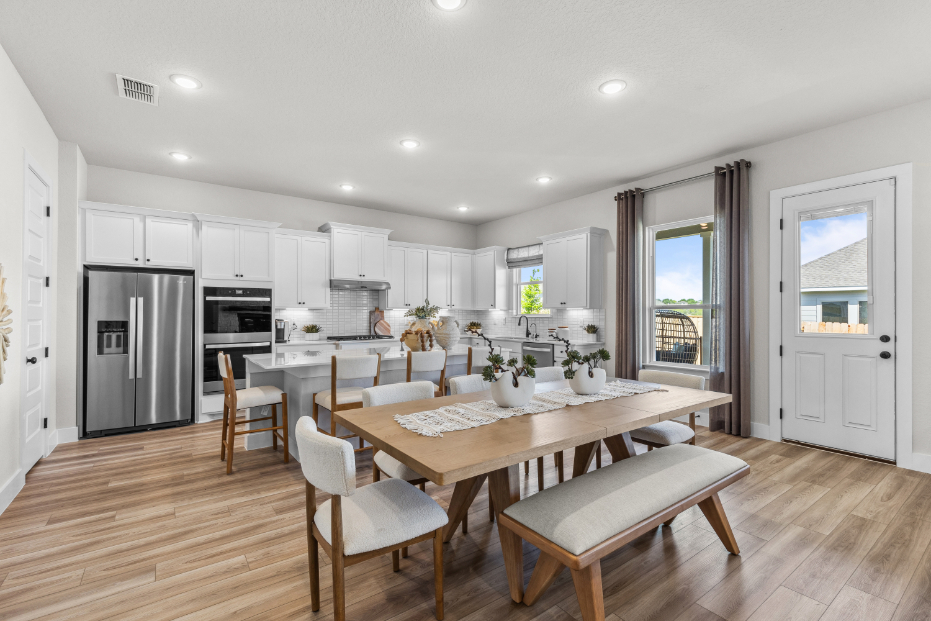 A kitchen with a dining table and chairs.