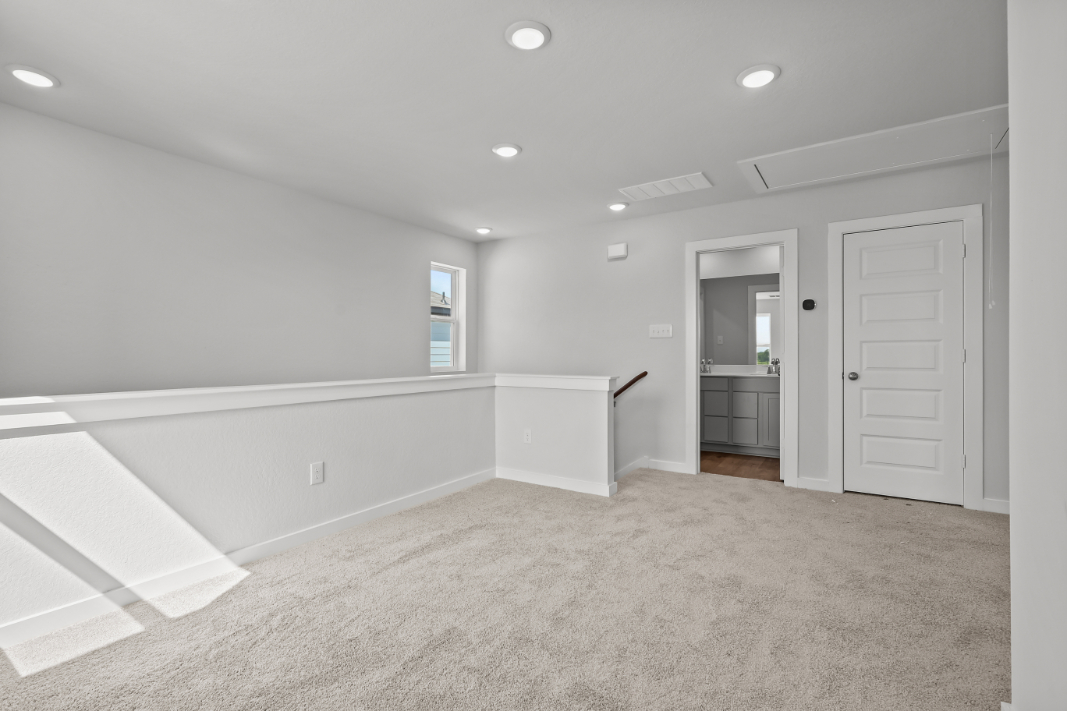 A room with white walls and a white staircase.