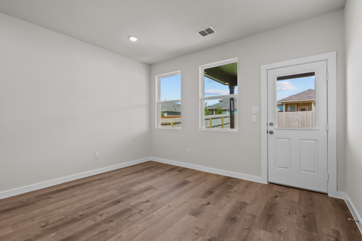 A room with a wood floor and a white door with a window.