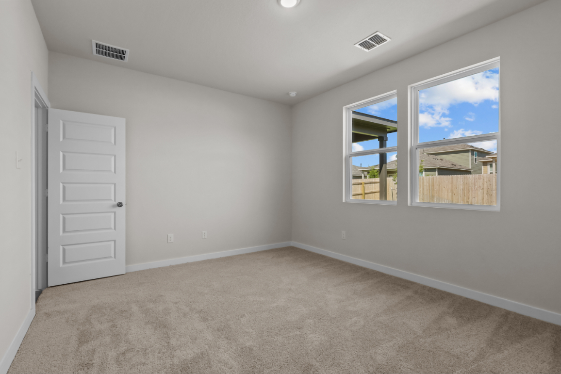 A room with white walls and a window with a view of the ocean.