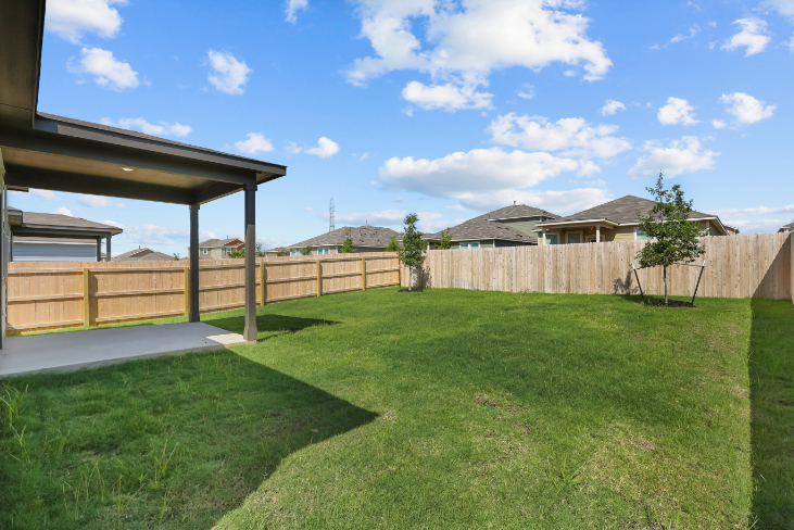 A backyard with a fence and trees.