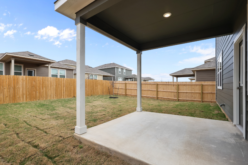 A backyard with a fence and a wood fence.