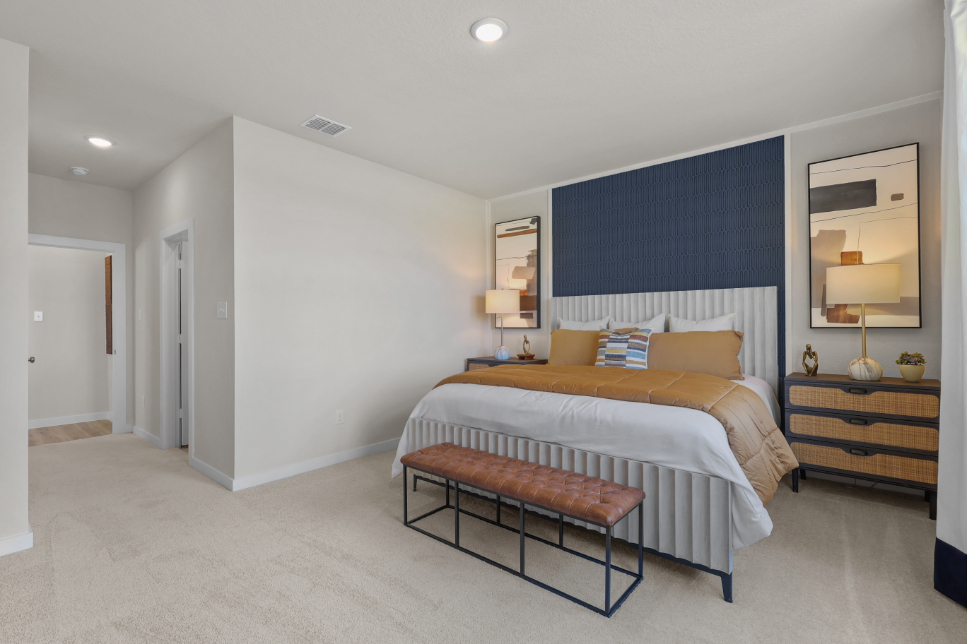 A bedroom with a bed and a bench.